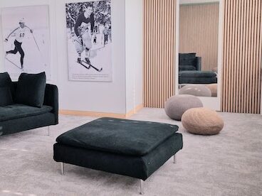 Einladend und modern gestaltetes USM-Buchregal im Büro mit Holzpaneelen, grün-grauem Ambiente von der Natur inspiriert.