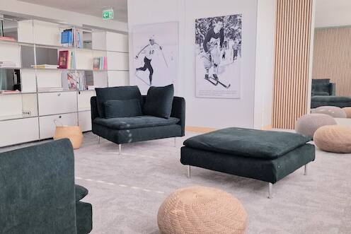 Einladend und modern gestaltetes USM-Buchregal im Büro mit Holzpaneelen, grün-grauem Ambiente von der Natur inspiriert.