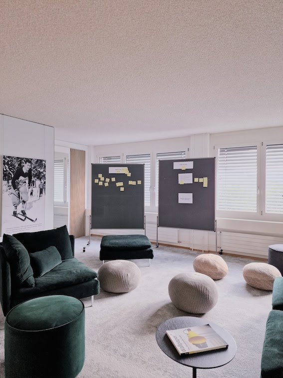 Einladend und modern gestaltetes USM-Buchregal im B&uuml;ro mit Holzpaneelen, gr&uuml;n-grauem Ambiente von der Natur inspiriert.