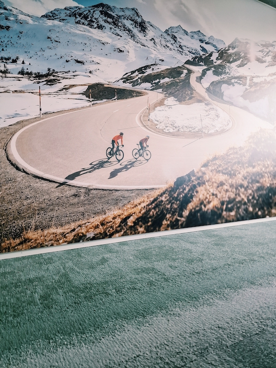 Sitzungszimmer mit XXL-Bild und grün-grauem Fliesenteppich, weisser Vitra Tisch
