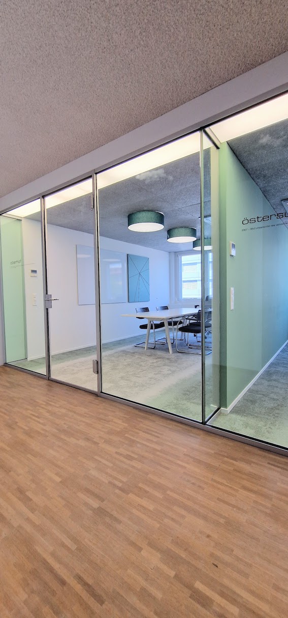 Sitzungszimmer mit Whiteboard und akustikoptimierender Pinnwand von Impact Acoustic und Interface Teppich in grün-grau.