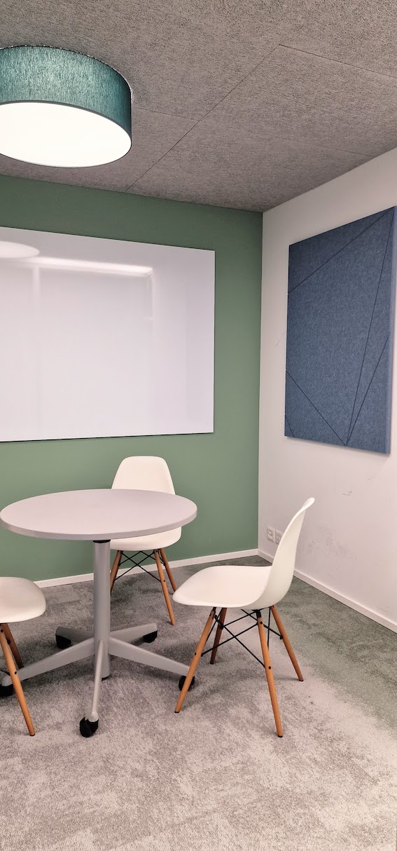 Sitzungszimmer mit Lifttisch, Whiteboard und akustikoptimierender Pinnwand von Impact Acoustic und Interface Teppich in grün-grau.