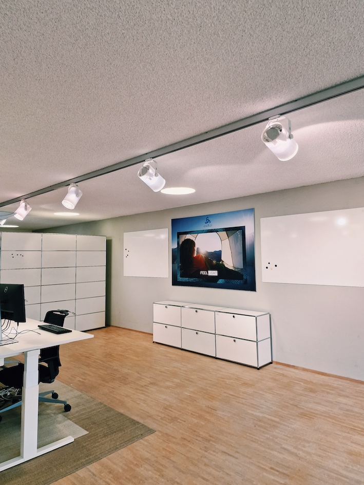 Ger&auml;umiger Projektraum mit Whiteboards, h&ouml;henverstellbaren Schreibtischen und modernen Drehst&uuml;hlen f&uuml;r produktives Arbeiten.